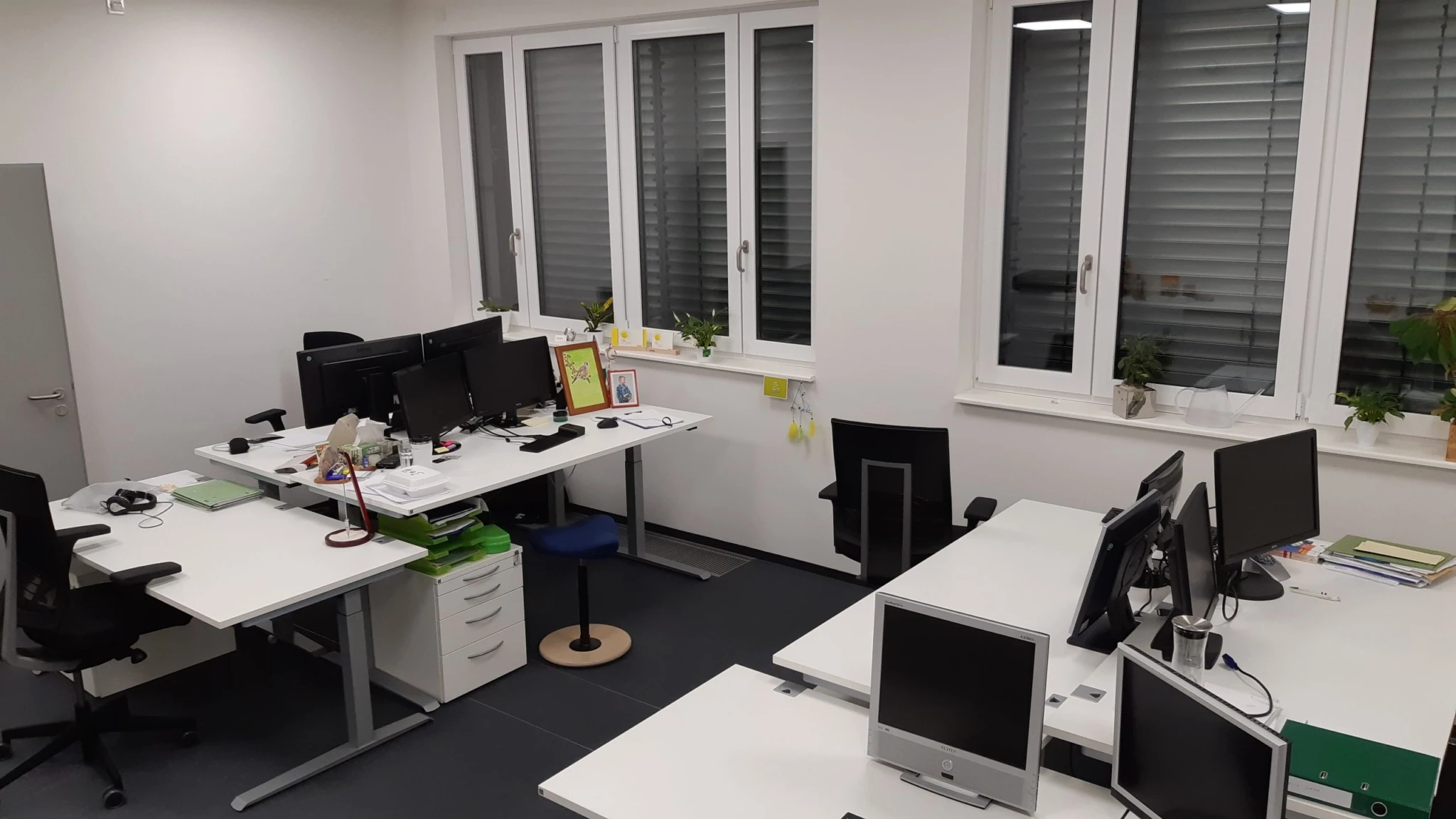Modernes Büro mit Computern, Pflanzen und Bürostühlen.