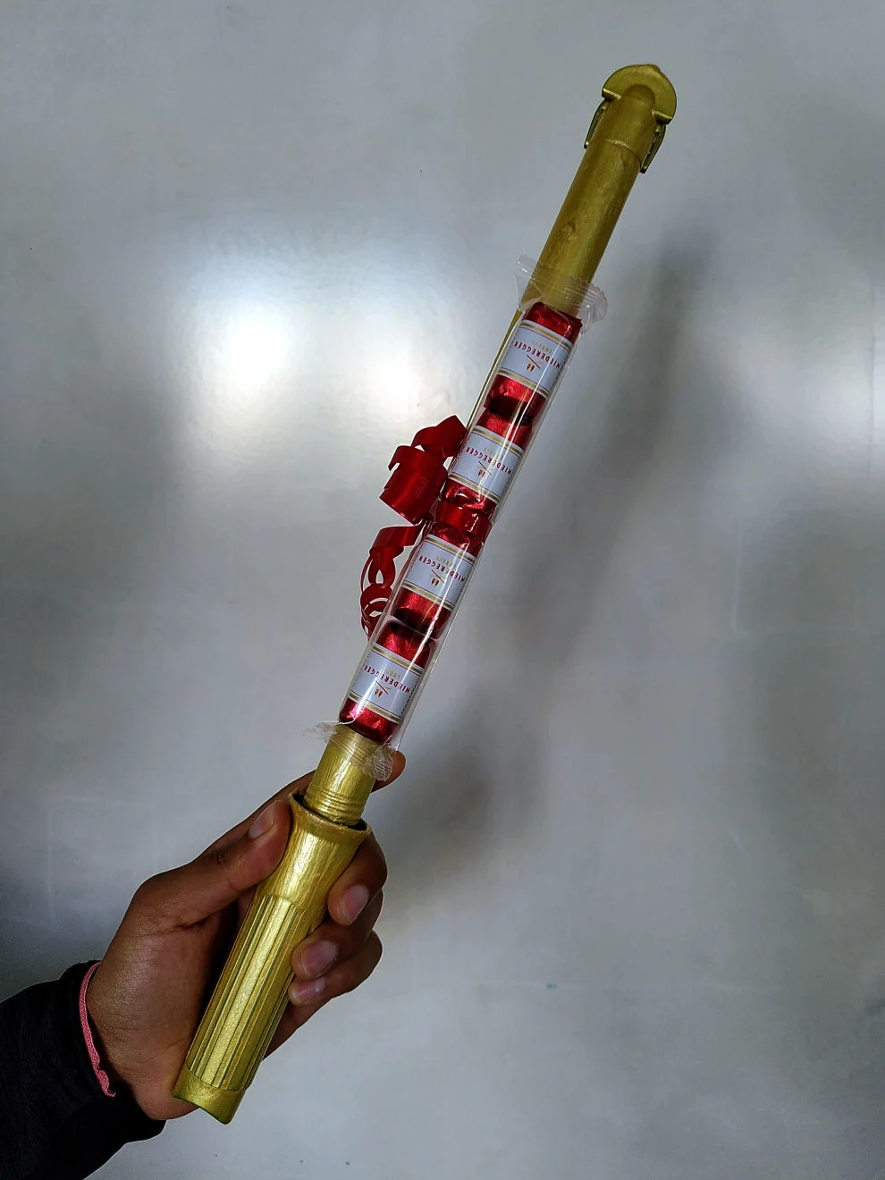 Hand hält die interne Peerox-Challenge-Trophäe mit rotem Band und goldfarbenem Griff.