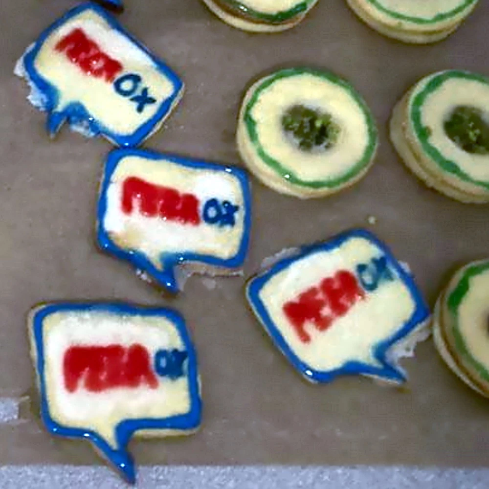 Es zeigt kleine runde Snacks und selbstgemachte Kekse mit dem PEEROX-Logo in Sprechblasenform