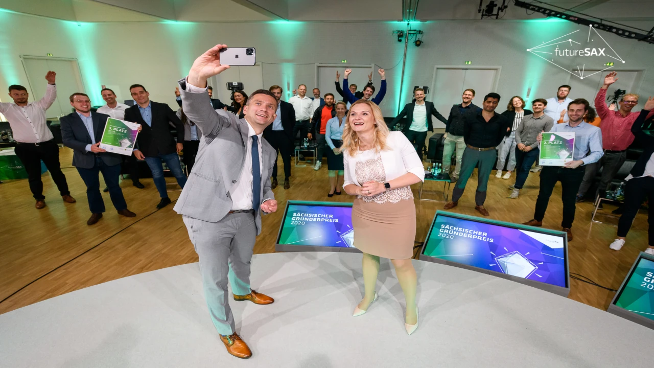 Selfie-Moment des Peerox-Teams bei der Preisverleihung des Sächsischen Gründerpreises 2020 mit jubelndem Publikum im Hintergrund.